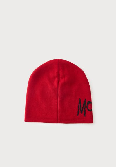 Bonnet en tricot rouge avec un détail partiel de texte noir sur un fond blanc uni.