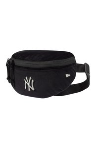 Riñonera negra de nailon con forma redondeada, cierre de cremallera, correa ajustable y un logo plateado de los New York Yankees en la parte frontal.
