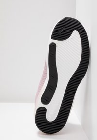 Ljusrosa sneaker med en texturerad mesh-övre, vit mellansula och svart gummisul med ett vågigt mönster.