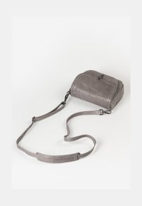 Borsa a tracolla in pelle grigia con forma tondeggiante, cuciture visibili e una tracolla rimovibile. Caratterizzata da una chiusura con zip e da una superficie liscia.