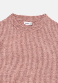 Rosa ribbestrikket genser med rund hals og et klesmerke som viser størrelse 9-10 år.