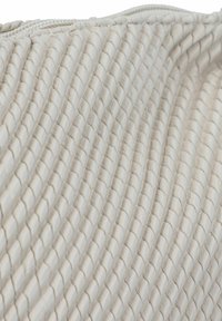 Geweven beige textiel met een diagonale ribbelpatroon. Soepele textuur met een subtiele glans. Ritsluiting aan de bovenkant.