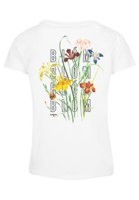 Witte T-shirt met korte mouwen met een bloemige graphic met gele, rode en blauwe bloemen en de tekst "BLÓM" in zwart, verticaal gerangschikt.