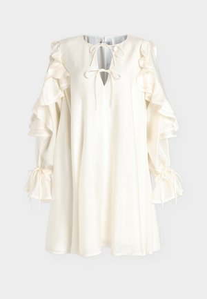 Robe blanche légère avec un col en V, des manches volantées et des liens aux poignets. Texture douce et design fluide avec une coupe décontractée.