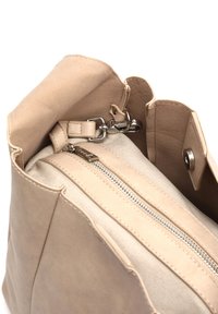 Beige nahka käsilaukku, jossa on pehmeä pinta, vetoketjullinen osio ja sisävuori kankaasta. Varustettu napsautuskannella ja metallisilla yksityiskohdilla.