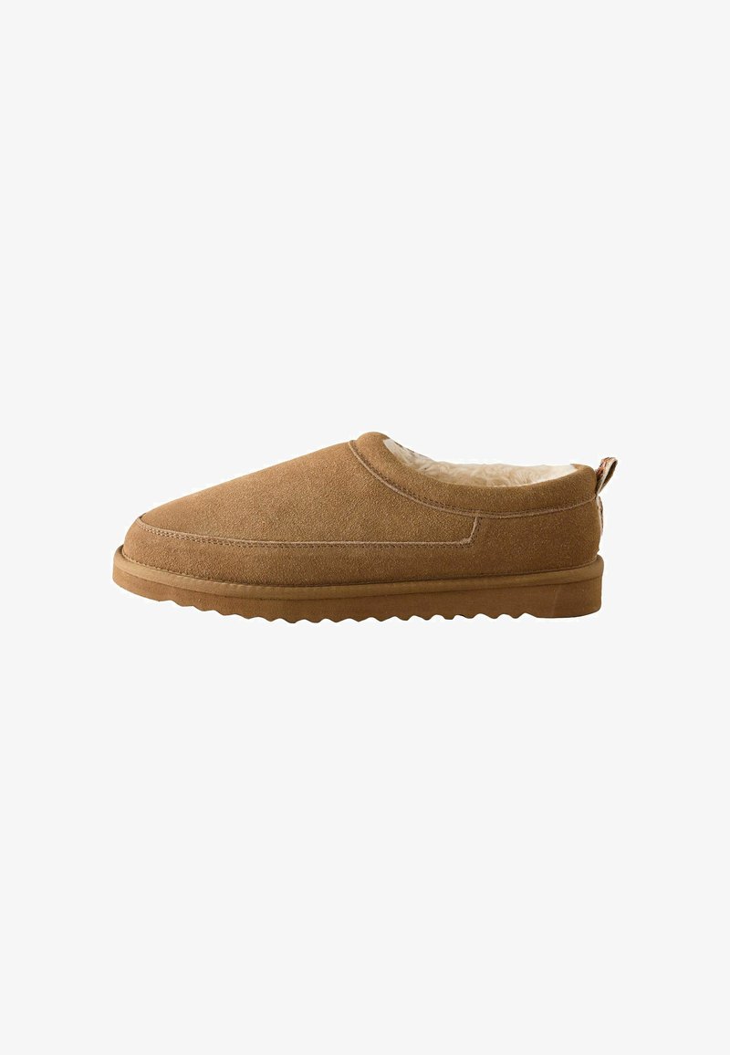 Pantofole slip-on in suede marrone con morbido rivestimento interno color crema e suola in gomma testurizzata, viste di lato su uno sfondo bianco.