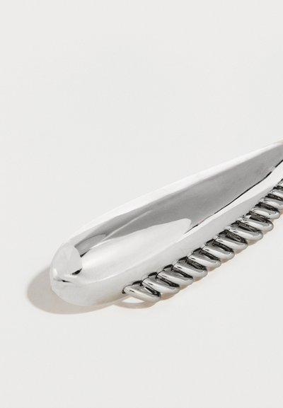 Μεταλλικό κλιπ μαλλιών, επιμήκης ασημένιος σχεδιασμός με λεία επιφάνεια. Διαθέτει διακριτικά δόντια κατά μήκος μιας ακμής για ασφαλή κράτημα.