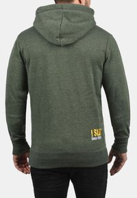 Green hoodie made of soft fabric, featuring a drawstring hood, ribbed cuffs, and hem, with a yellow graphic text detail on the lower back.