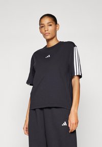 Schwarzes Baumwoll-T-Shirt mit kurzen Ärmeln, ausgestattet mit drei weißen Streifen am linken Ärmel und einem kleinen weißen Logo auf der Brust.