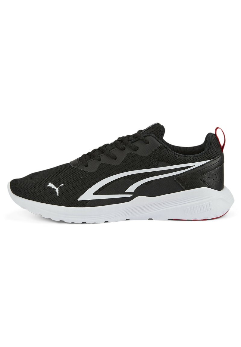 Zapatilla deportiva negra con upper de malla texturizada, suela blanca y logotipo y acentos blancos en contraste. Presenta cordones y una lengüeta trasera.