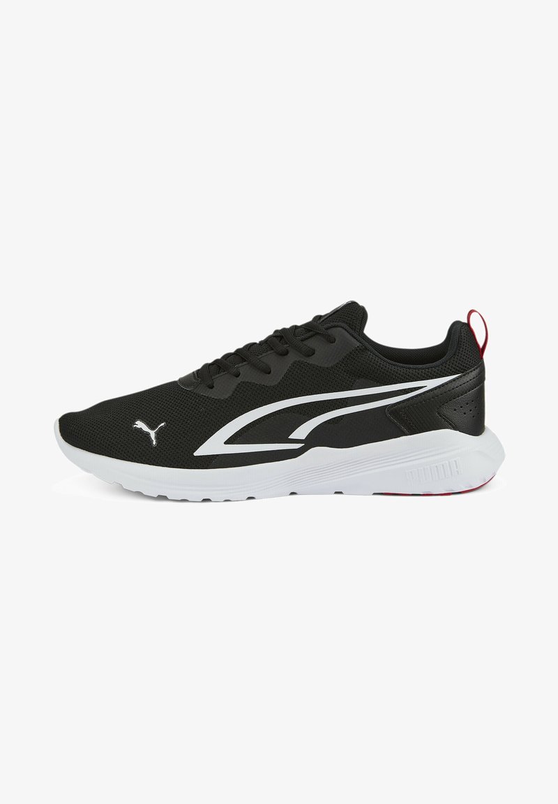 Zapatilla deportiva negra con upper de malla texturizada, suela blanca y logotipo y acentos blancos en contraste. Presenta cordones y una lengüeta trasera.