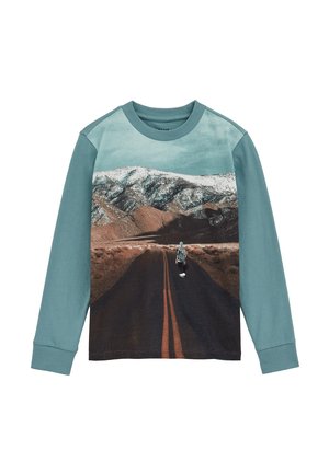 Felpa a maniche lunghe con colletto tondo in teal, immagine di uno skateboarder su una strada, con montagne e neve sullo sfondo.
