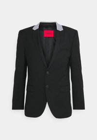 Zwarte blazer van gladde stof, met een grijze kraagaccent, enkelvoudig ontworpen, twee voorkreten en een gedurfde rode merketiket.
