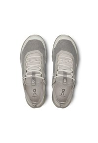 Scarpe da ginnastica grigio chiaro con una tomaia in rete, suole imbottite e un logo sui lati. Presentano lacci e un tallone sagomato per il supporto.