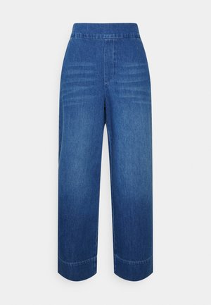 Jean en denim bleu à taille haute et jambes larges, sans poches visibles, présentés sur fond blanc.