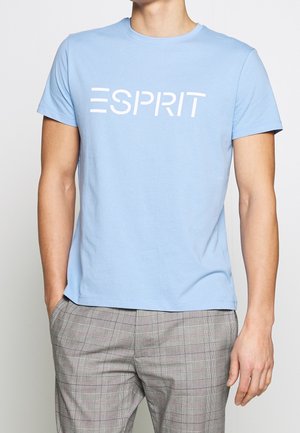 Jasnoniebieska bawełniana koszulka z okrągłym dekoltem i krótkimi rękawami, z dużym białym napisem "ESPRIT" na przodzie.