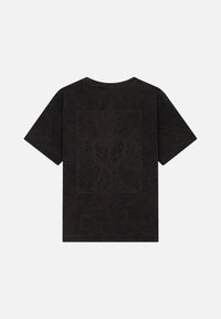 Donkerbruine katoenen t-shirt met korte mouwen, met een decoratieve afgedrukte afbeelding op de achterkant in een lichtere kleur, omrand door abstracte patronen.