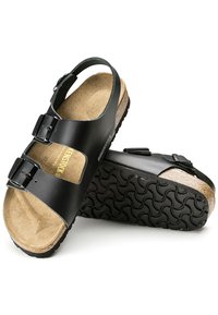 Svarta Birkenstock-sandaler med två justerbara spännen, korkfotbädd och strukturerad gummisula. Slätt ovansidematerial och öppen design.