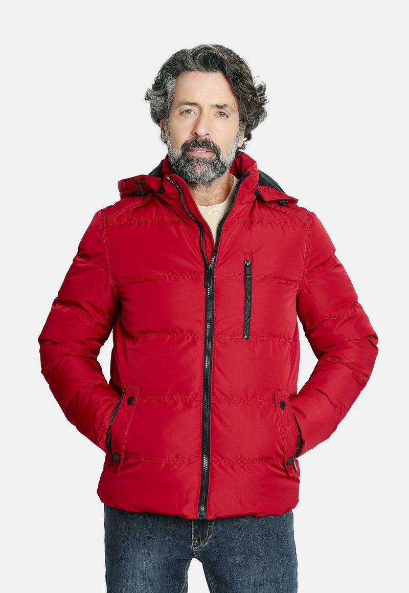 Chaqueta acolchada roja con cierre de cremallera, bolsillos laterales y capucha. Presenta un exterior texturizado y acentos negros en las cremalleras.