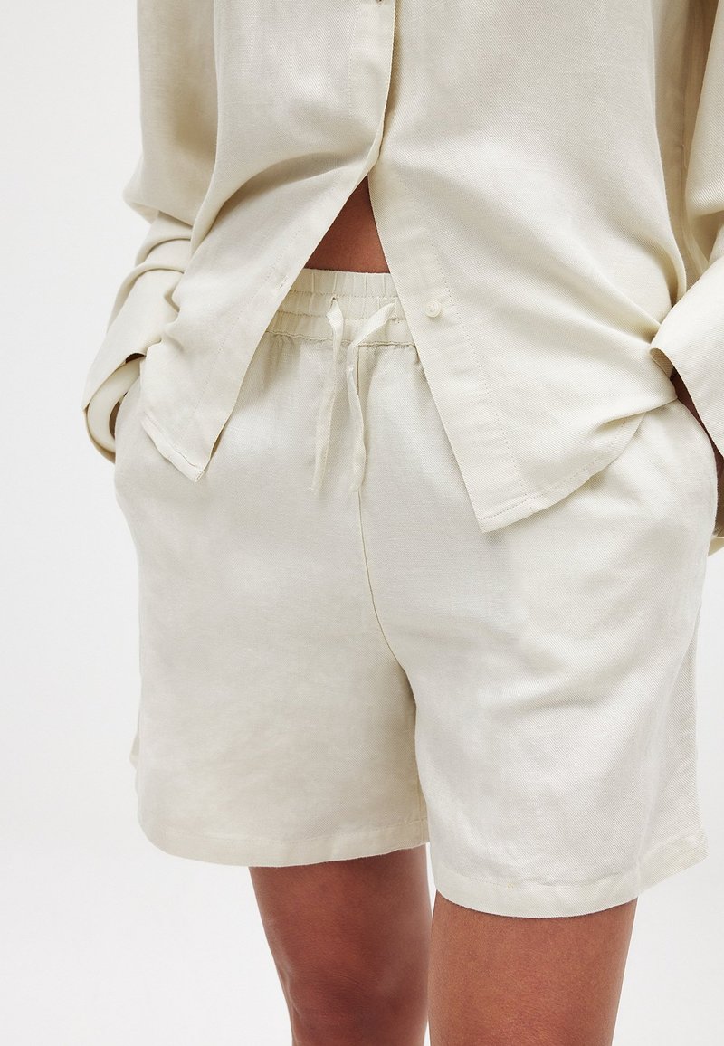 Linnen korte set in lichtbeige met een ontspannen pasvorm; heeft een button-down shirt met opgerolde mouwen en een verstelbare tailleband op de shorts.
