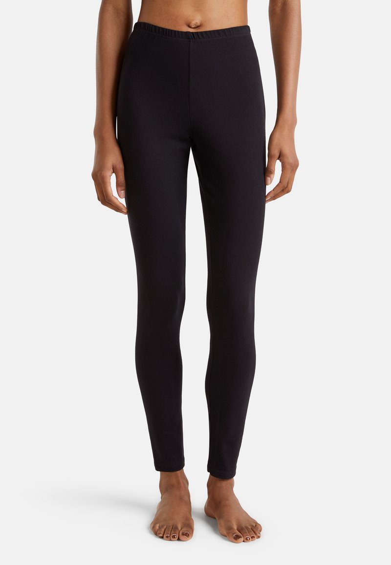 Leggings noirs en tissu extensible avec une taille élastique. Conception ajustée, texture lisse, longueur cheville, sans motifs visibles ni accessoires.