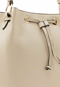 Borsa a spalla in pelle beige con finitura testurizzata, dotata di accessori in metallo tono oro, chiusura a strappo e accenti neri a contrasto.