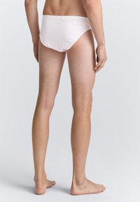 Witte katoenen slips met een eenvoudig ontwerp, lage taille, en zachte textuur, met nauwelijks zichtbare naden en zonder opvallende hardware.
