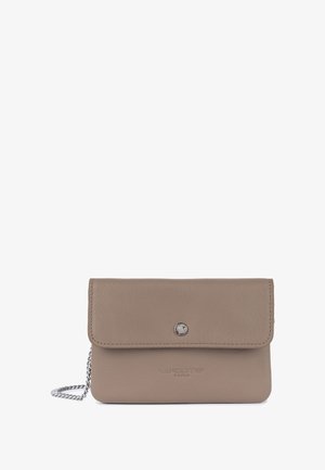 Beige leather clutch with a fold-over flap, silver hardware, and embossed "LANCASTER PARIS" logo. Features a chain strap for versatility.