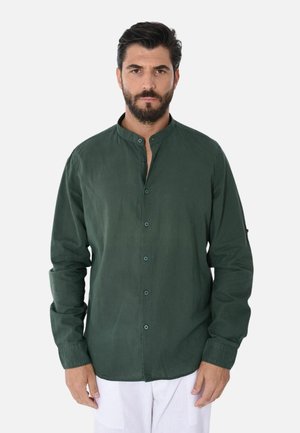 Camicia verde con colletto alla cinese, maniche lunghe e vestibilità rilassata. Realizzata in un tessuto morbido con una leggera lucentezza.