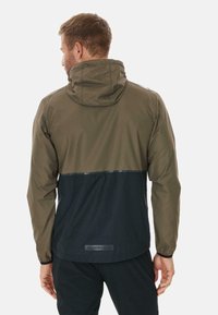 Wasserabweisende Jacke mit einem zweifarbigen Design: olivgrüner Oberteil und schwarzer Unterteil. Mit Kapuze und elastischen Bündchen.
