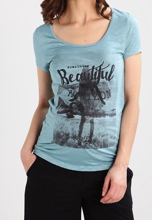 Light blue short-sleeve t-shirt in soft fabric features a graphic print with the text "something Beautiful" and a scenic design.
