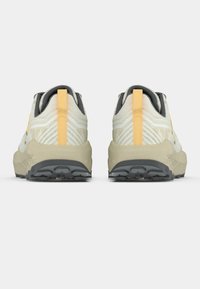 Kerged maastikujooksujalatsid kreemikas ja hallis toonis, tekstureeritud pealse ja kollaste aktsentidega, vastupidava halli kummist tald.