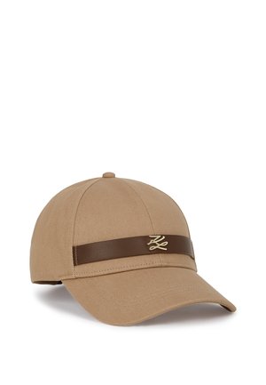 Tan fabric baseball cap with a curved brim. Features a brown leather band and a small gold emblem on the front. Textured material.