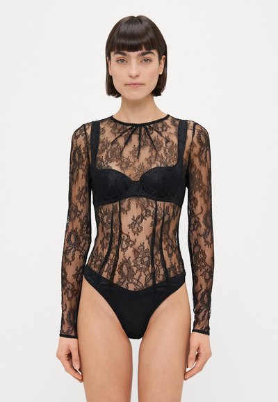 Sort blonde bodysuit med lange ærmer, prydet med blomster mønstre og en tætsiddende pasform, har en sweetheart-udskæring og matchende trusser.