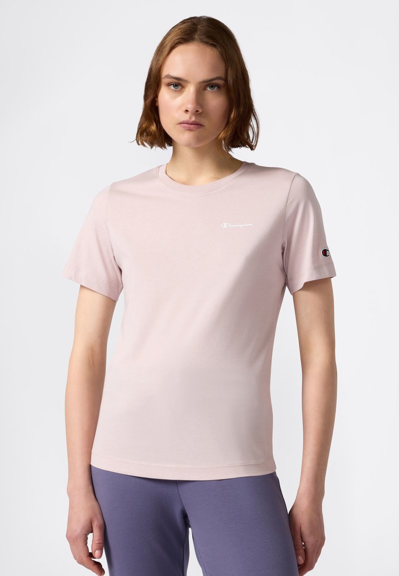 T-shirt rosa chiaro a maniche corte realizzato in morbido cotone. Presenta un piccolo logo bianco sul petto e una patch con il logo sulla manica sinistra.
