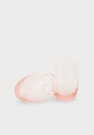 Deux verres à boire translucides roses avec des motifs de papillons, l'un debout et l'autre couché sur le côté.