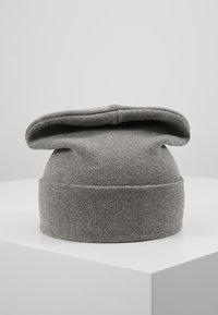 Gorro de punto gris con ala enrollada y textura suave. Presenta un diseño plegado y una construcción sin costuras, ideal para mantener el calor.