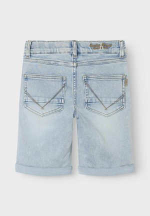 Lys blå denimshorts med middels vask, med to baklommer med trekantsting og rullet kant. Merkevarelogo på linningen.