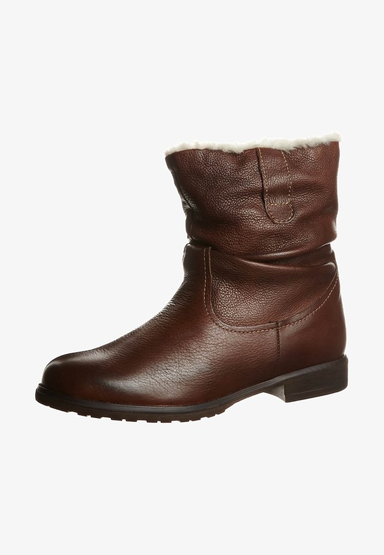 Botte cheville en cuir marron avec semelle en caoutchouc plate et doublure en laine blanche visible au niveau du bord supérieur, conçue pour les temps froids.