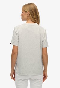 Lysegrå T-shirt med korte ærmer i blød bomuldsblanding, med et enkelt design med rund halsudskæring og en lille logodetalje på ærmet.