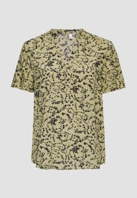 Blouse à manches courtes en tissu vert clair, avec un motif floral noir, décolleté en V et coupe décontractée. Texture douce et légère.