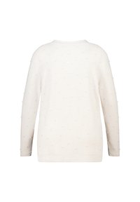 Lichtbeige trui met lange mouwen, voorzien van textuurelementen in de vorm van stippen, een ronde halslijn en een losse pasvorm. De zachte stof lijkt pluizig.