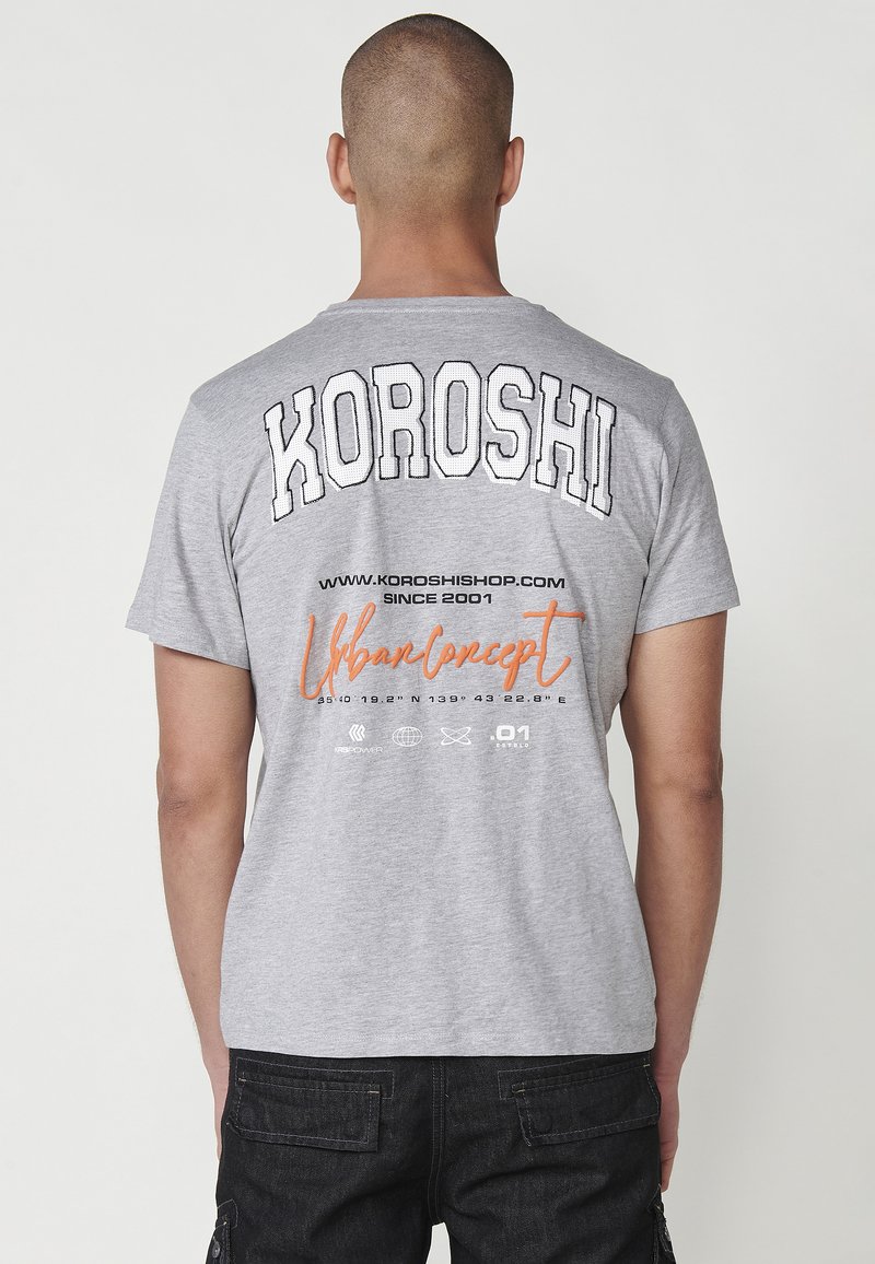 Gray cotton t-shirt featuring bold black "KOROSHI" lettering on the back, orange "Urban Concept," and various printed details.
