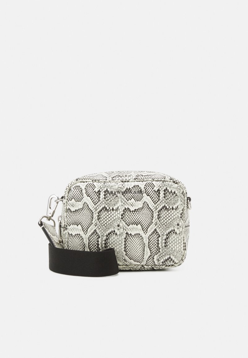 Textured, gray and white snakeskin-patterned crossbody bag with a black strap and silver hardware. Zip closure and branded detail visible.