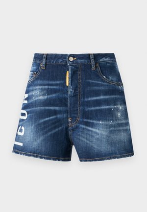 Calções de ganga em azul escuro com um acabamento desbotado, apresentando o texto branco "ICON" na perna esquerda e uma etiqueta de tecido laranja perto da cintura.