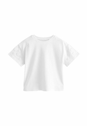 T-shirt en coton blanc à manches courtes, avec un motif floral brodé sur les manches, col rond et une coupe décontractée et courte.