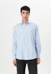 Blå og hvit stripete langermet skjorte med krage, knappelukking foran og buet hem. Stoffet ser glatt og lett ut.