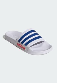 White slide sandal with three navy stripes across the top. Features a textured footbed and a red "adidas" logo on the side.