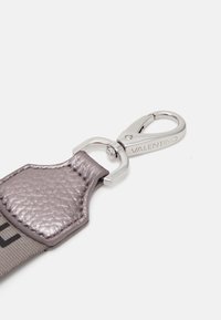 Přívěsek na klíče Valentino s klipem ve stříbrné barvě a šedým koženým páskem s tkaným vzorem.