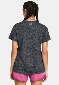 Black athletic t-shirt in a textured, moisture-wicking fabric, featuring short sleeves and a logo on the upper back.